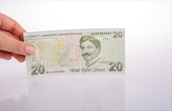 Hand holding Turksh Lira banknote on white background