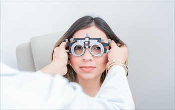 Ophthalmologist examining patient with optometrist trial frame. Doctor adjusting vision of patient with optometrist trial frame