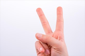 Hand making Victory Symbol on a white background