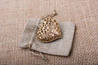 Heart shaped gold color metal object out of sack