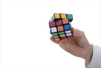 Child holding a Rubik's cube in hand on a white background