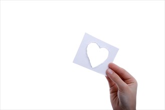 Hand holding a heart shape paper cut out of paper on a white background