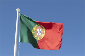 National flag of Portugal against a blue sky in Sagres