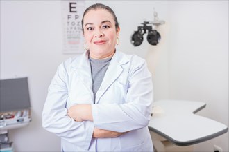 Portrait of female optometrist with arms crossed in the laboratory. Smiling female oculist with arms crossed in office