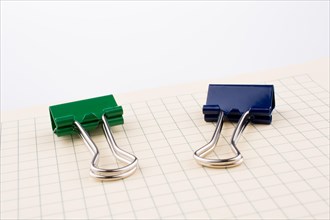 Colored paper clip on a checked notebook page