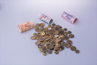 Turkish Lira coins and banknotes side by side on white background