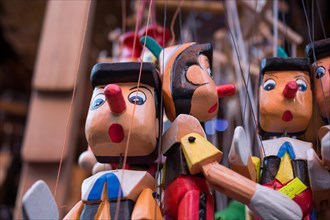 Set of wooden pinocchio dolls with his long nose on a white background