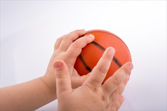Baby holding an orange basketball model on a white background