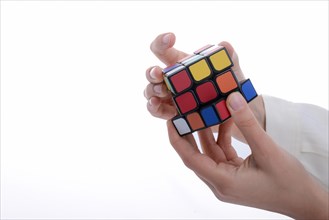 Child holding a Rubik's cube in hand on a white background