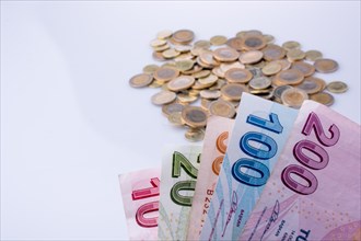 Turkish Lira coins and banknotes side by side on white background