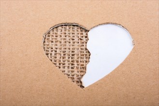 Paper and canvas seen through heart shape hole out of cardboard