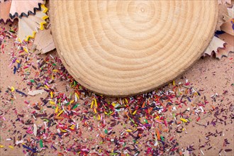 Colorful pencil shavings and a piece of wood