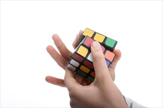 Child holding a Rubik's cube in hand on a white background