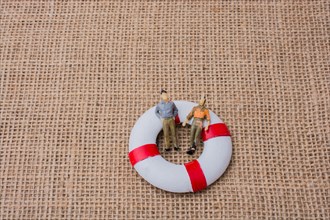 Little figurine men in a life preserver on life on canvas