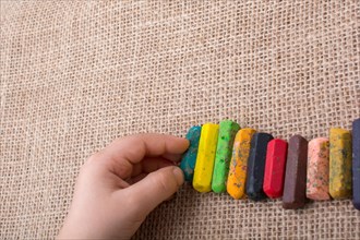 Toddlers hand putting crayons in line on canvas