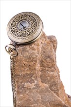 Pocket watch on the top of a rock on a white background