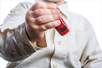 Baby hand holding a red car on a white background