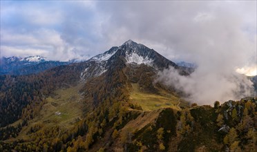 Aerial view of Corno di Gesero with clouds and autumn forest in the foreground