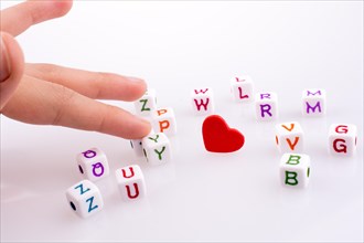 Heart between Letter cubes on a white background