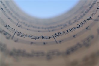 Circular rolled sheet music with blue blurred background