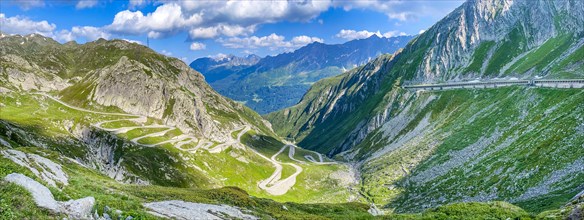 PanoramafoView of old southern pass road Tremola south ramp with serpentines narrow hairpin bends on steep mountain slope of Gotthard Pass on left