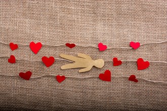 Paper man and heart icons on linen threads on canvas