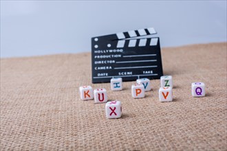 Colorful letter cubes beside a director clapper board