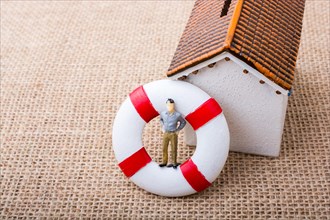 Model house and a life preserver with a man figure on it