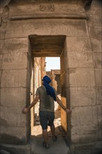 Portrait of a young man with a blue turban at the entrance to the Edfu Temple near the city of Aswan. Egypt