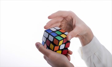 Child holding a Rubik's cube in hand on a white background