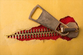 Torn paper with hole on a colorful zipper