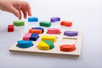Colorful wooden pieces of a logic puzzle in hand