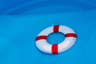 Little red and white color model life buoy in water