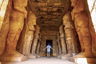 A young tourist looking at the pharaohs at the Abu Simbel Temple in southern Egypt in Nubia along Lake Nasser. Temple of Pharaoh Ramses II