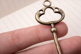 Hand holding a retro styled golden color decorative key