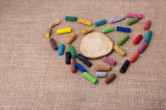 Wood piece in the middle of crayons form a heart shape