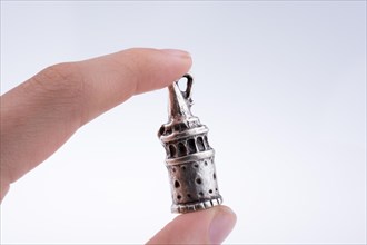 Hand holding a Galata Tower model on a white background