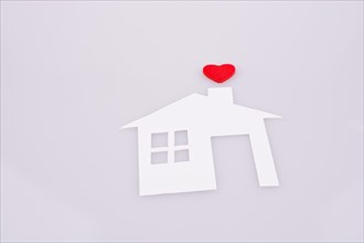 White paper house with a small red heart