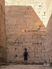 A young tourist visiting the beautiful temple of Edfu in the city of Edfu