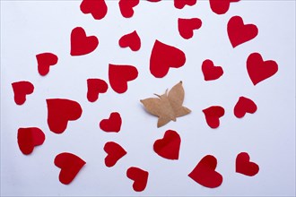 Paper butterfly and paper hearts in red color