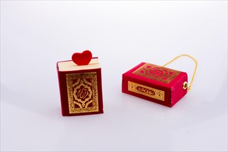 The Holy Quran with a heart on a white background