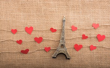 Love concept with Eiffel tower and paper heart on threads