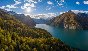 Aerial view in front of sunset over the autumnal forest at Lago di Luzzone in Valle di Blenio