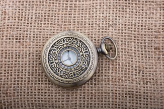 Mechanical retro styled pocket watch on linen canvas