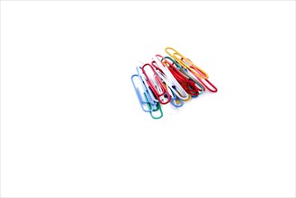 Colurful paperclips piled on a white background