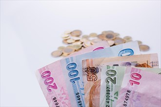 Turkish Lira coins and banknotes side by side on white background