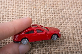 Colorful little toy car in hand on white background