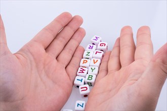 Hand playing with Letter cubes on a white background