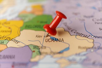 Ukraine marked with a red thumbtack on a map with an out-of-focus background