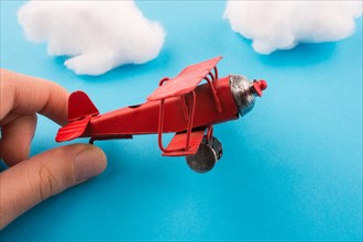 Retro styled red model airplane in hand